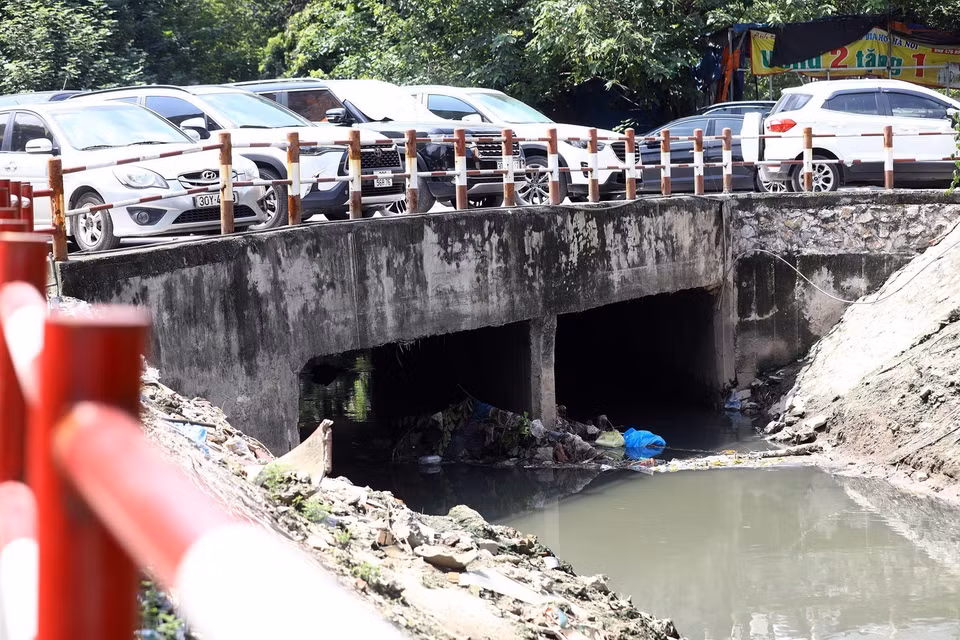 Một đoạn cửa cống bị rác thải đọng lâu ngày khiến dòng chảy bị ảnh hưởng đáng kể khi mưa to.(Ảnh: Huy Hùng/TTXVN)