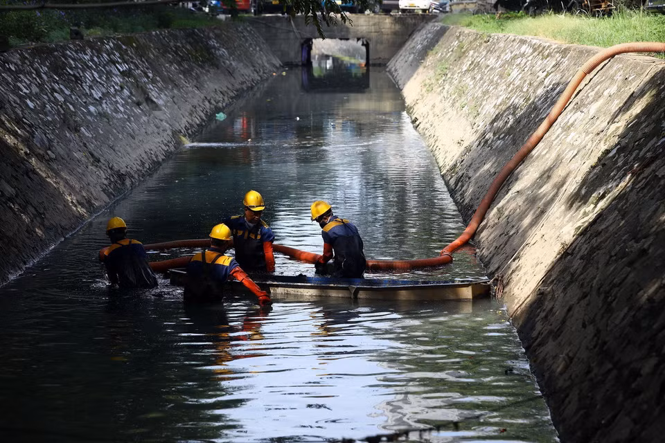 Công nhân Xí nghiệp thoát nước số 6 Hà Nội nạo vét lòng kênh trên địa bàn phường Trung Hòa, quận Cầu Giấy để nâng cao năng lực thoát nước. (Ảnh: Huy Hùng/TTXVN)