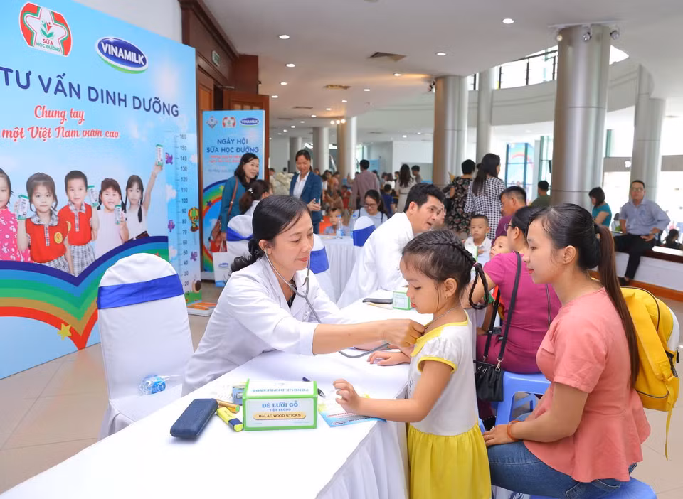 Các bác sỹ đến từ Trung tâm Tư vấn Dinh dưỡng Vinamilk khám và tư vấn dinh dưỡng cho các em học sinh tại Ngày hội sữa học đường Đà Nẵng. (Nguồn: P.V/Vietnam+)