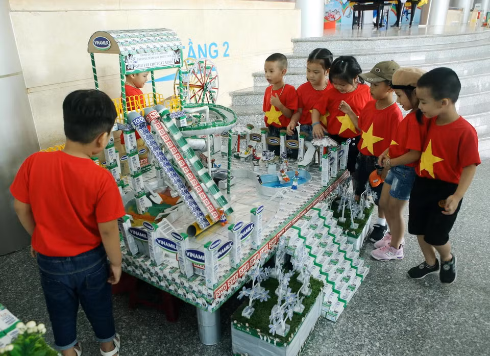 Phụ huynh học sinh và các em nhỏ thích thú xem các đồ dùng, đồ chơi, mô hình từ vỏ hộp sữa đã qua sử dụng tại Ngày hội sữa học đường Đà Nẵng. (Nguồn: P.V/Vietnam+)