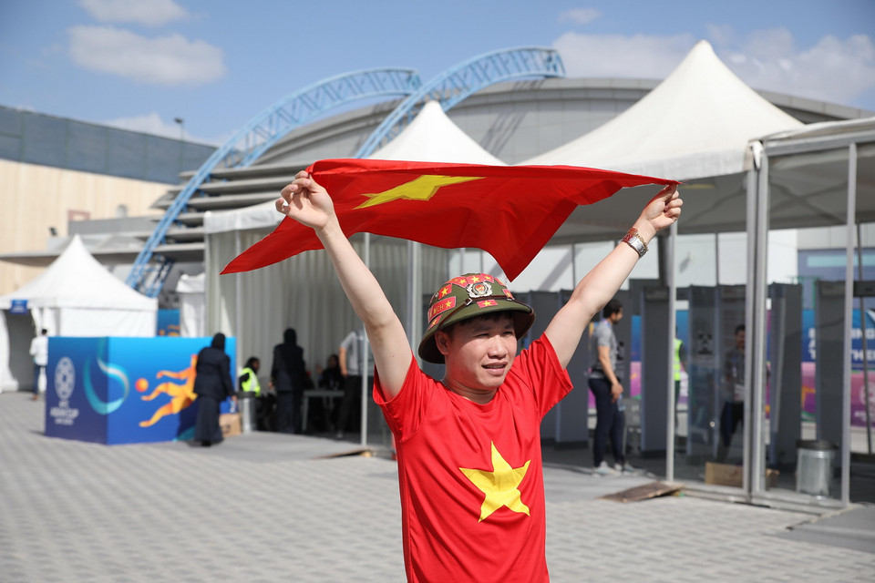 Cổ động viên với lá cờ Tổ quốc bên ngoài sân Al-Maktoum, Dubai. (Ảnh: Hoàng Linh/TTXVN)