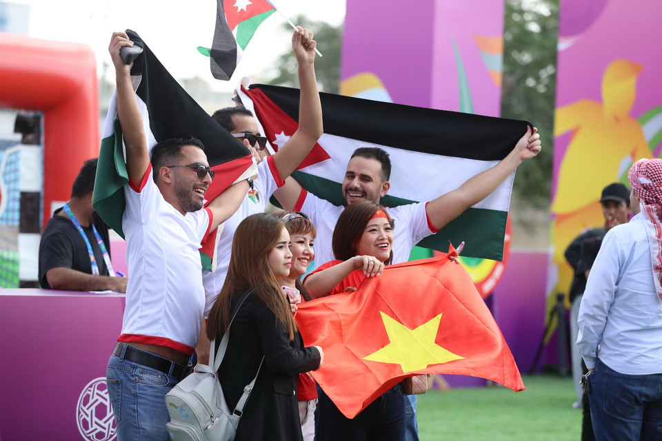 Cổ động viên Việt Nam và Jordan chụp ảnh chung bên ngoài sân vận động Al-Maktoum. (Ảnh: Hoàng Linh/TTXVN)