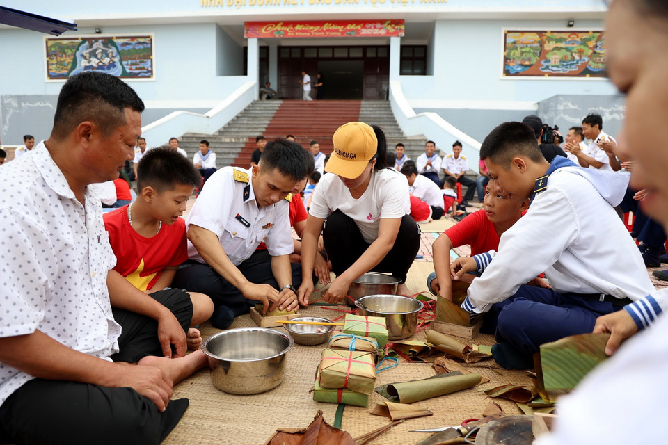 Các chiến sỹ cùng nhân dân trên đảo Đá Tây thi gói bánh chưng đón Tết. (Ảnh: Hồng Đạt/TTXVN)