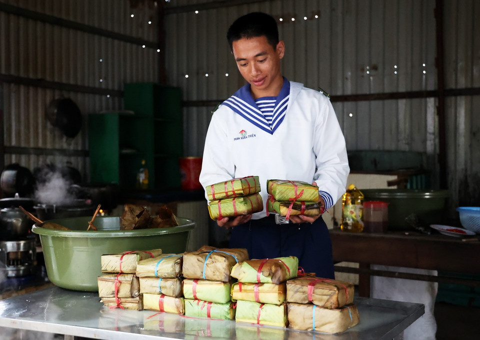 Chiến sỹ Phan Xuân Thiện bên các cặp bánh chưng mới vớt. (Ảnh: Hồng Đạt/TTXVN)