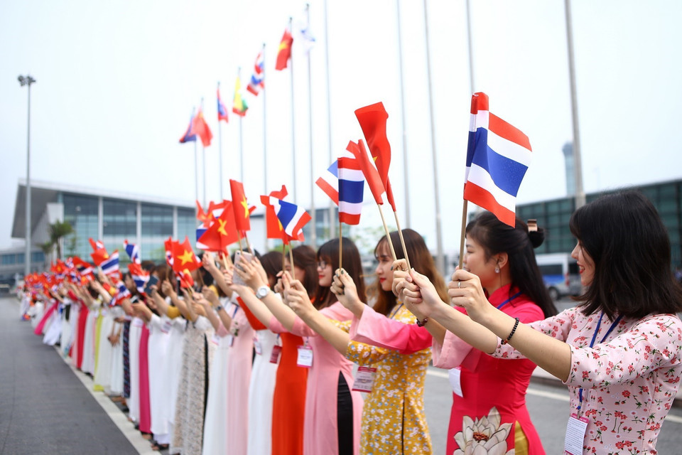 Thiếu nữ Thủ đô vẫy cờ hai nước chào đón Thủ tướng Thái Lan Prayuth Chan-ocha tới Việt Nam. (Ảnh: TTXVN)