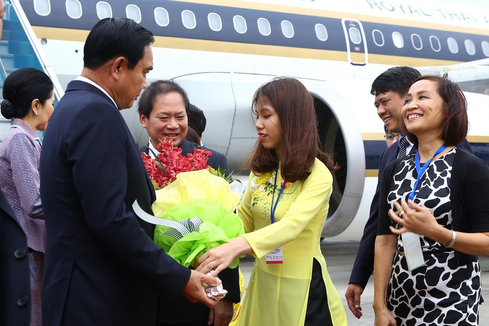 Thiếu nữ Hà Nội tặng hoa chào mừng Thủ tướng Thái Lan Prayuth Chan-ocha. (Ảnh: TTXVN)