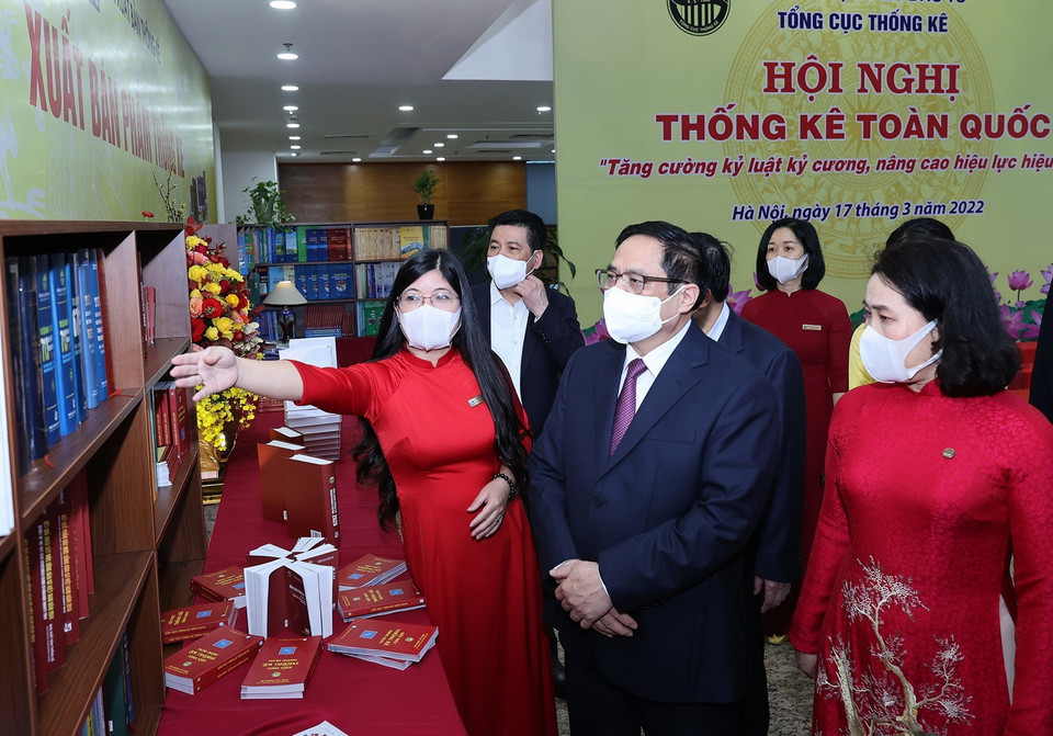 Nhân viên ngành thống kê giới thiệu với Thủ tướng Phạm Minh Chính về sách, hình ảnh, hiện vật của ngành thống kê. (Ảnh: Dương Giang/TTXVN)