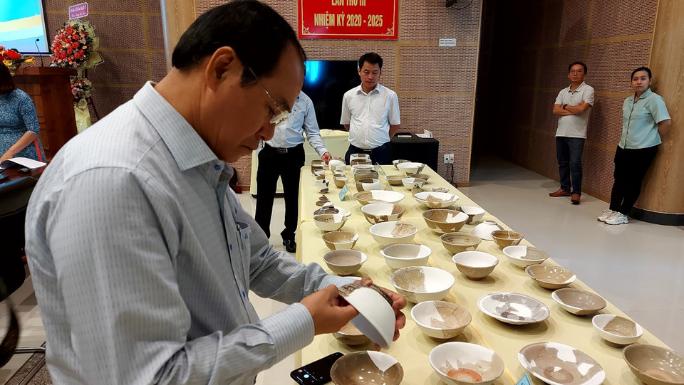 Các đại biểu tham quan nhóm đồ sứ, đồ bán sứ và đồ sành được khai quật tại di tích Vòng Thành Đá Trắng. (Ảnh: Huỳnh Sơn/TTXVN)