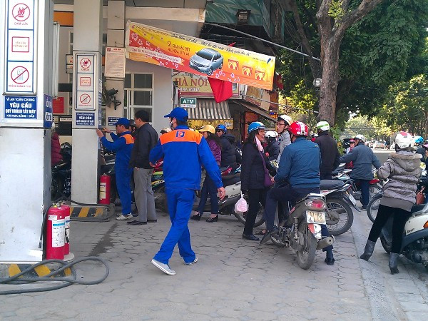 Người tiêu dùng "sững sờ" với thông báo về giá xăng tăng. (Ảnh: PV/Vietnam+)