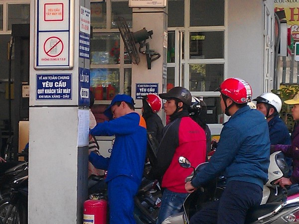 Nhân viên cây xăng dán thông báo. (Ảnh: PV/Vietnam+)