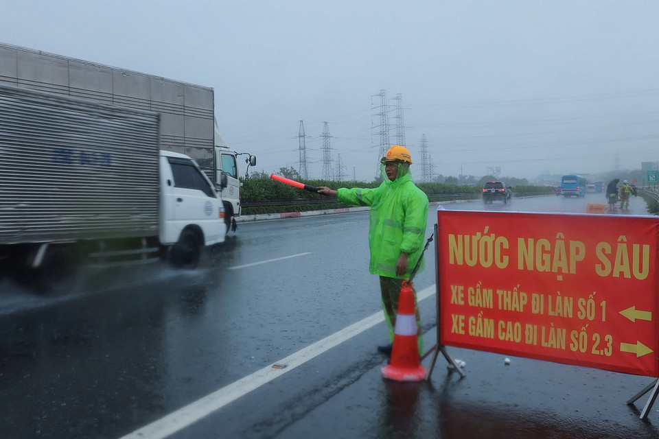 Lực lượng chức năng cảnh báo, phân làn xe trước khi đi vào đoạn ngập từ Km191-192 trên tuyến cao tốc Pháp Vân-Cầu Giẽ (ảnh chụp lúc 10 giờ 30 phút ngày 11/9). (Ảnh: Hoàng Hiếu/TTXVN)
