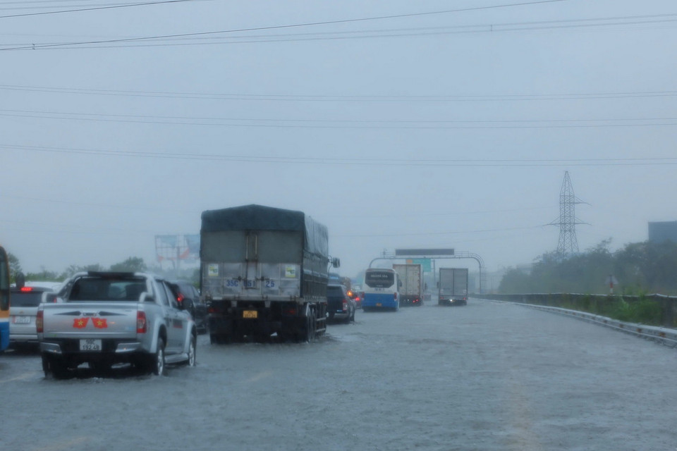 Các phương tiện di chuyển chậm qua đoạn ngập Km 191+500 trên cao tốc Pháp Vân-Cầu Giẽ (ảnh chụp lúc 10h30 ngày 11/9). (Ảnh: Hoàng Hiếu/TTXVN)