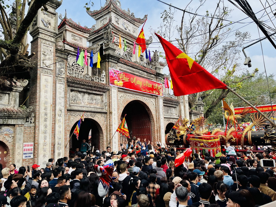 Đám rước pháo di chuyển từ nhà truyền thống đến sân Đình. (Ảnh: Đỗ Huyền/TTXVN)