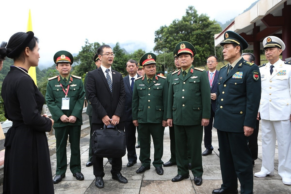 Đại tướng Ngô Xuân Lịch và Thượng tướng Ngụy Phượng Hòa nghe giới thiệu về Khu di tích lịch sử Pác Bó. (Ảnh: Dương Giang/TTXVN)
