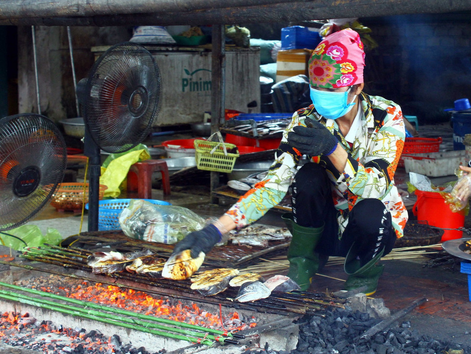  Các công nhân làm nghề nướng cá tại xã Nghi Thủy đang làm liên tục không có thời gian nghỉ để phục vụ nhu cầu cá thu nướng của người dân trong dịp Tết. (Ảnh: Tá Chuyên/TTXVN)