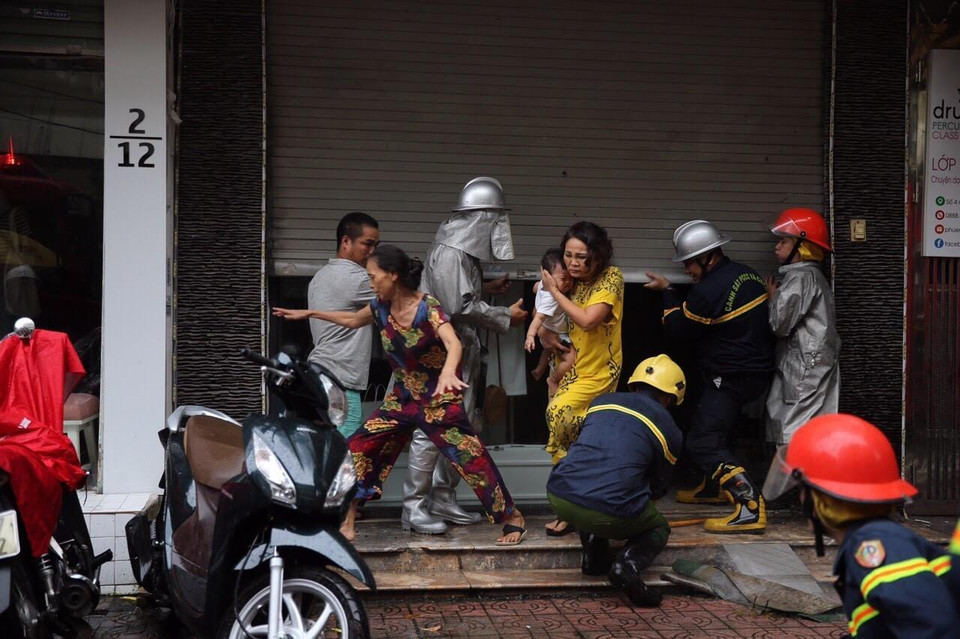 Lực lượng chữa cháy đưa người dân ra khỏi hiện trường. Ảnh: Dương Giang/TTXVN)
