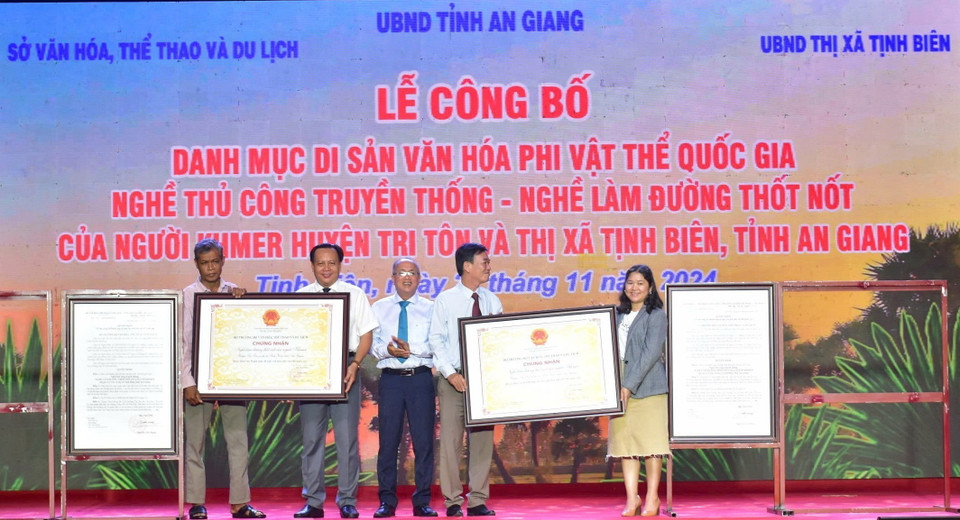 Phó Giám đốc Sở Văn hóa, Thể thao và Du lịch tỉnh An Giang Trương Bá Trang (thứ 3, trái) trao Quyết định của Bộ trưởng Bộ Văn hóa, Thể thao và Du lịch công nhận nghề làm đường thốt nốt của đồng bào dân tộc thiểu số Khmer huyện Tri Tôn và thị xã Tịnh Biên, tỉnh An Giang, là Di sản Văn hóa Phi vật thể Quốc gia. (Ảnh: Công Mạo/TTXVN)