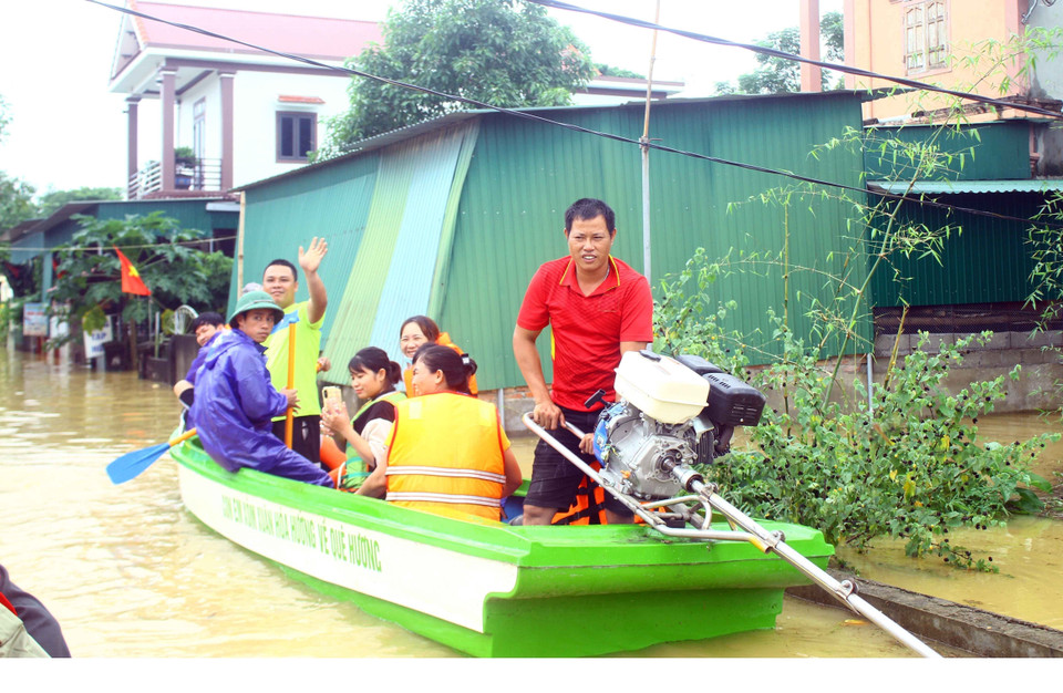 Chính quyền xã Thanh Xuân (huyện Thanh Chương, tỉnh Nghệ An) dùng xuồng máy di dời người dân tại các vùng bị ngập sâu đến nơi an toàn. (Ảnh: Tá Chuyên/TTXVN)