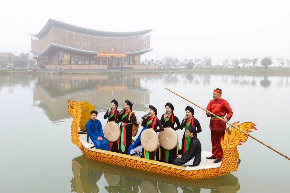 Liền anh, liền chị hát Quan họ giao lưu với khán giả trên thuyền. (Ảnh: Đoàn Công Vũ/TTXVN phát)