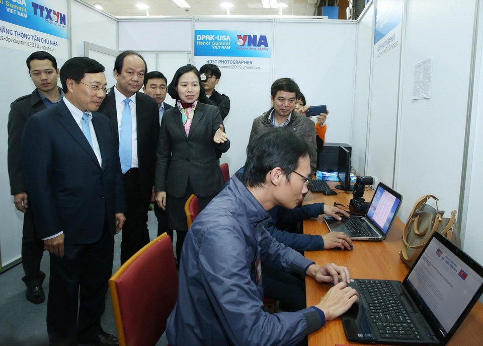 Phó Tổng Giám đốc TTXVN Vũ Việt Trang báo cáo với Phó Thủ tướng, Bộ trưởng Bộ Ngoại giao Phạm Bình Minh công tác chuẩn bị, sẵn sàng đưa tin về Hội nghị Thượng đỉnh Mỹ-Triều Tiên lần hai. (Ảnh: Lâm Khánh TTXVN)