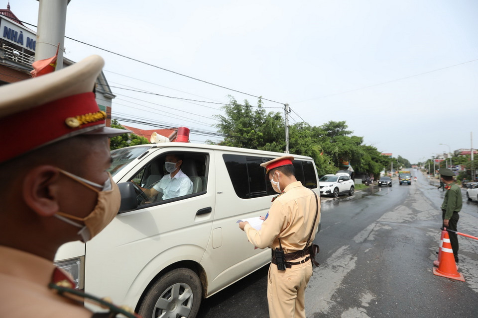  Lực lượng chức năng tại chốt kiểm soát đầu cầu Trung Hà (huyện Ba Vì) kiểm tra giấy tờ của người và phương tiện khi qua chốt. (Ảnh: Minh Quyết/TTXVN)