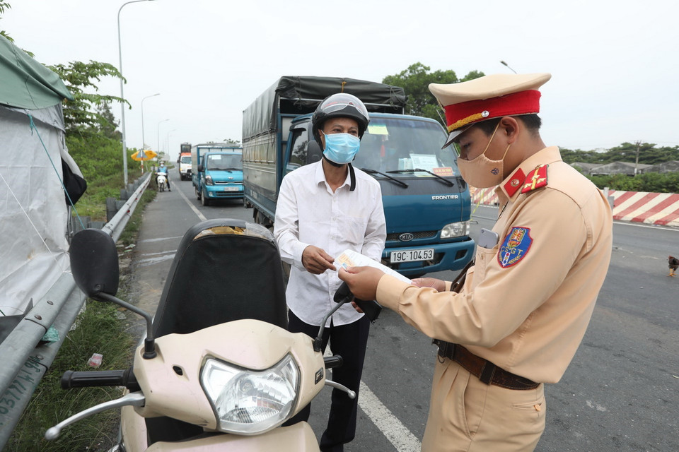  Lực lượng chức năng kiểm tra giấy tờ của người tham gia giao thông khi qua chốt. (Ảnh: Minh Quyết/TTXVN)