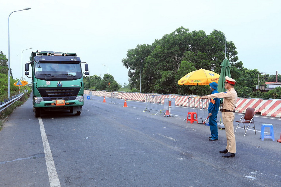  Lực lượng chức năng kiểm tra, kiểm soát tại chốt kiểm dịch đầu cầu Vĩnh Thịnh, thị xã Sơn Tây. (Ảnh: Tuấn Anh/TTXVN)