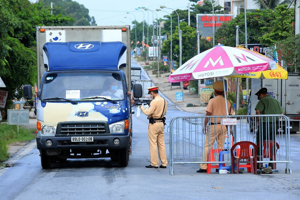  Cảnh sát giao thông Đội 6 (Công an Hà Nội) kiểm tra các phương tiện ra, vào thành phố tại chốt kiểm dịch đầu cầu Trung Hà, huyện Ba Vì. (Ảnh: Tuấn Anh/TTXVN)