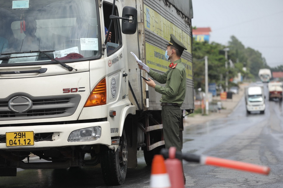  Lực lượng chức năng tại chốt kiểm soát đầu cầu Trung Hà (huyện Ba Vì) kiểm tra giấy tờ của người và phương tiện khi qua chốt. (Ảnh: Minh Quyết/TTXVN)