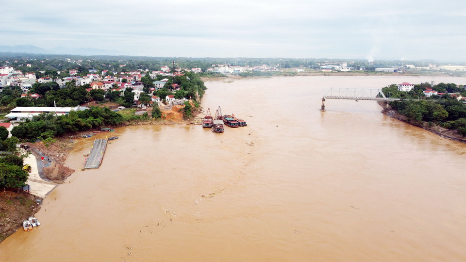 Theo lực lượng chức năng, mực nước sông Hồng dâng cao, nhiều cây cối, vật cản trôi mắc vào cầu phao đã gây áp lực quá mức cho cầu cần phải thực hiện đóng cầu để đảm bảo an toàn. (Ảnh: Tạ Toàn/TTXVN)
