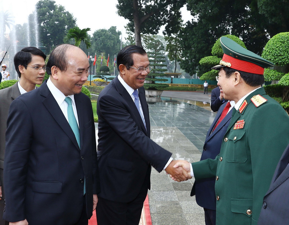 Thủ tướng Campuchia Samdech Techo Hun Sen bắt tay các thành viên chính thức đoàn Việt Nam tham dự lễ đón. (Ảnh: Thống Nhất/TTXVN)