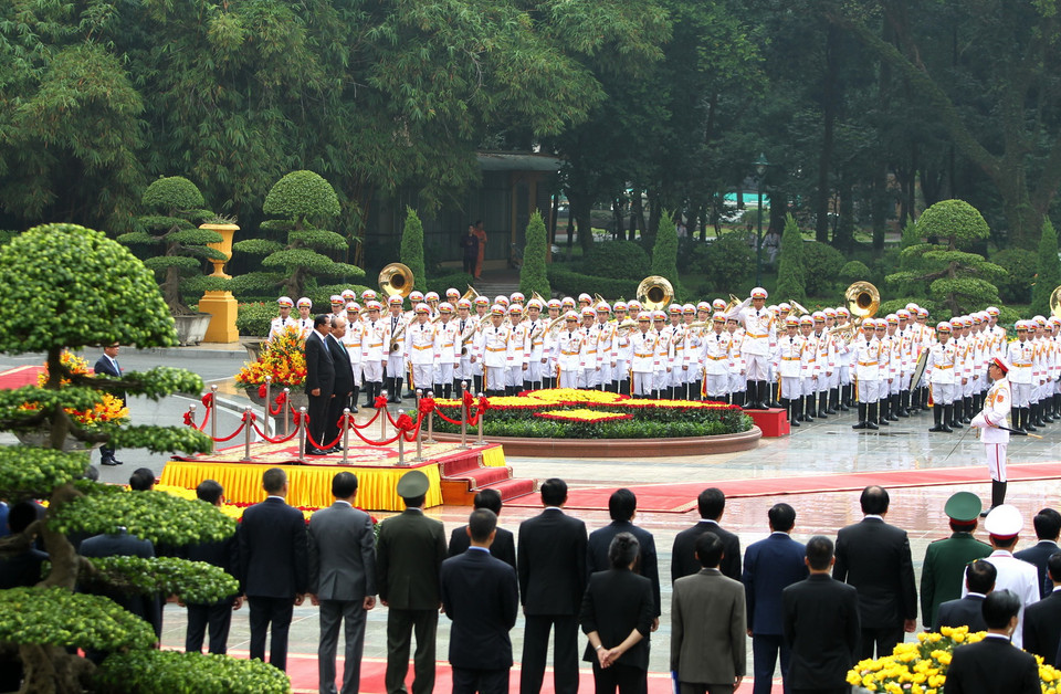 Thủ tướng Nguyễn Xuân Phúc và Thủ tướng Campuchia Samdech Techo Hun Sen trên bục danh dự, thực hiện nghi lễ chào cờ. (Ảnh: Văn Điệp/TTXVN)