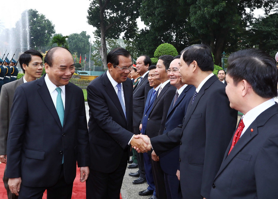 Thủ tướng Campuchia Samdech Techo Hun Sen bắt tay các thành viên chính thức đoàn Việt Nam tham dự lễ đón. (Ảnh: Thống Nhất/TTXVN)