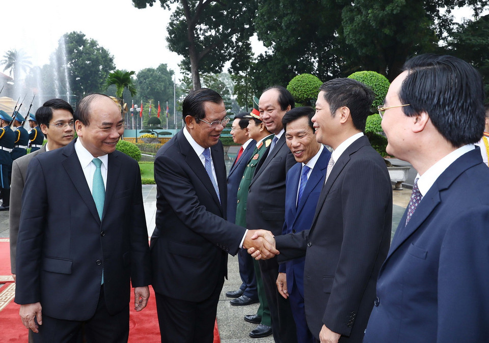 Thủ tướng Campuchia Samdech Techo Hun Sen bắt tay các thành viên chính thức đoàn Việt Nam tham dự lễ đón. (Ảnh: Thống Nhất/TTXVN)
