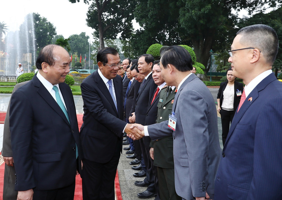 Thủ tướng Campuchia Samdech Techo Hun Sen bắt tay các thành viên chính thức đoàn Việt Nam tham dự lễ đón. (Ảnh: Thống Nhất/TTXVN)