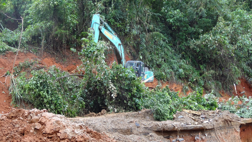 Triển khai phương tiện cơ giới khắc phục điểm sạt lở để tiếp cận hiện trường. (Ảnh: TTXVN phát)