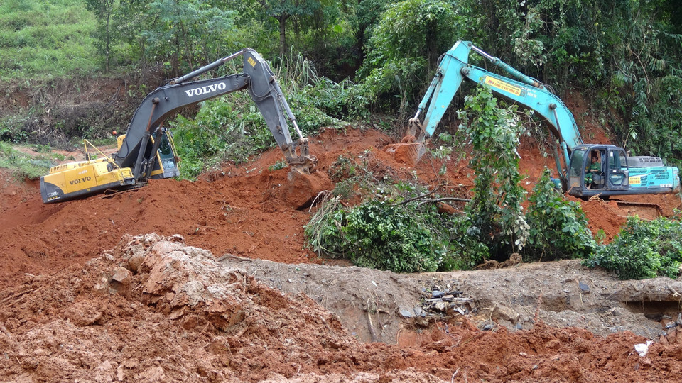 Triển khai phương tiện cơ giới khắc phục điểm sạt lở để tiếp cận hiện trường. (Ảnh: TTXVN phát)