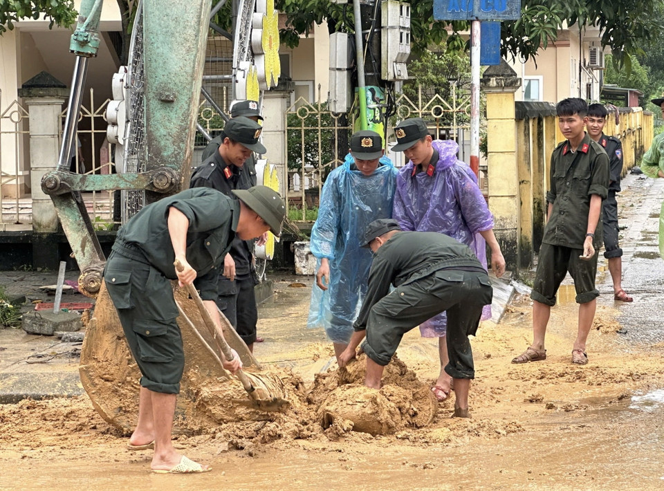 Lực lượng công an tỉnh Phú Thọ giúp người dân dọn dẹp, vệ sinh đường xá. (Ảnh: Tạ Toàn/TTXVN)