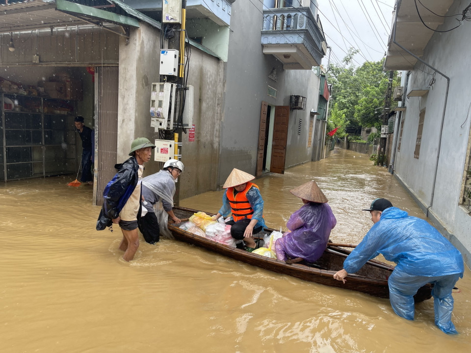Các tổ chức, cá nhân vượt mưa gió cứu trợ người dân nằm trong vùng bị ngập ở thị trấn Hạ Hòa. (Ảnh: Tạ Toàn/TTXVN)