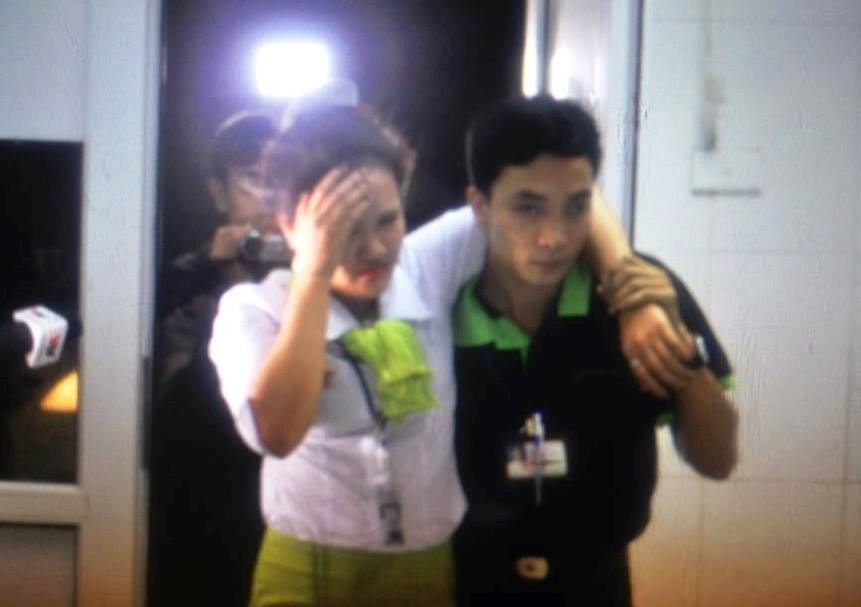 Một nhân viên được hỗ trợ trong tình trạng choáng váng. (Ảnh: Minh Sơn/Vietnam+)