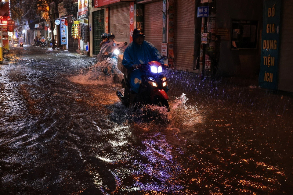 Người dân đi lại khó khăn khi trời mưa to. (Ảnh: Tuấn Anh/TTXVN)