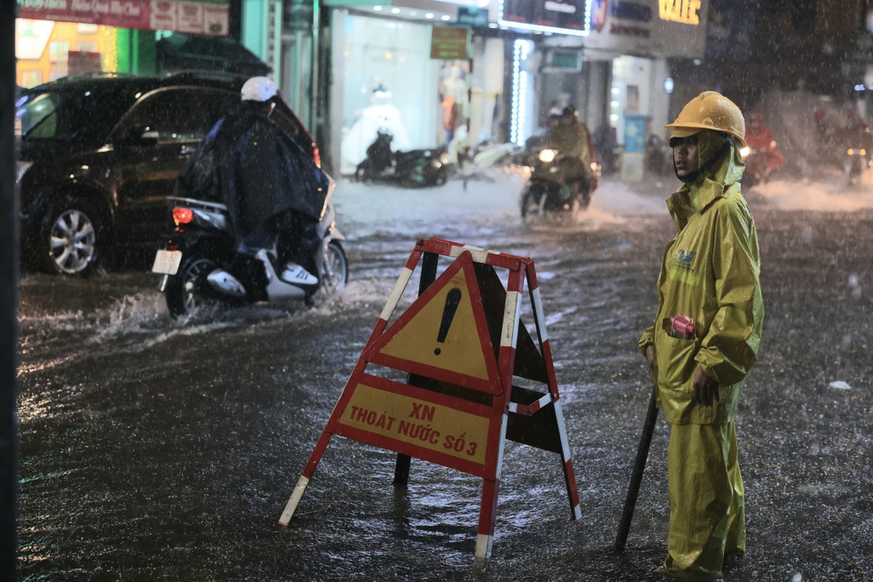 Công nhân Xí nghiệp thoát nước số 3 ứng trực trên phố Bạch Mai, quận Hai Bà Trưng. (Ảnh: Hoàng Hiếu/TTXVN)