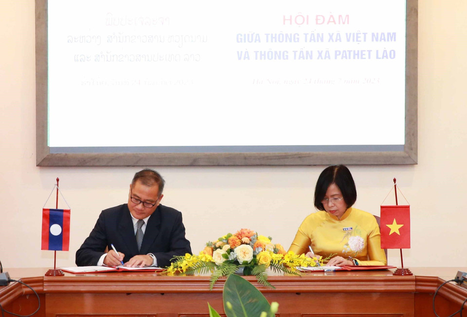 Tổng giám đốc Thông tấn xã Việt Nam Vũ Việt Trang và Tổng giám đốc Thông tấn xã Pathet Lào Khampheuy Philapha ký Biên bản ghi nhớ hợp tác giữa hai cơ quan. (Ảnh: Phương Hoa/TTXVN)