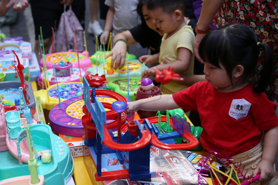 Các em bé thích thú với đồ chơi tại phố Hàng Mã trong Tết Trung Thu. (Ảnh: Hoàng Hiếu/TTXVN)