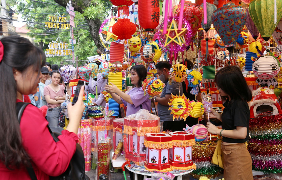 Các bạn trẻ lưu giữ kỷ niệm tại phố Hàng Mã. (Ảnh: Hoàng Hiếu/TTXVN)