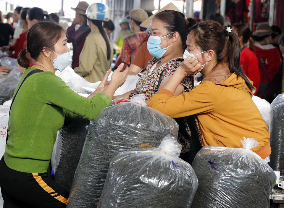  Những người mua trao đổi sau khi đã mua được một lượng chè nhất định. (Ảnh: Trần Việt/TTXVN)