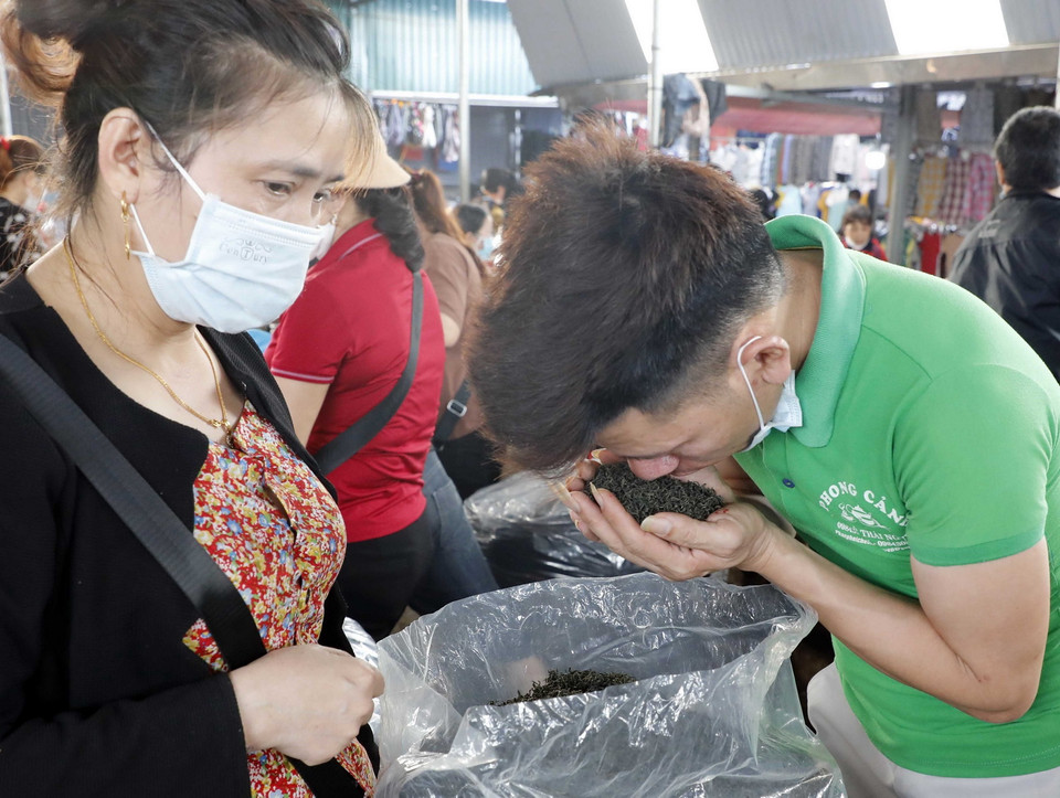  Người mua thử hương của chè khô. (Ảnh: Trần Việt/TTXVN)