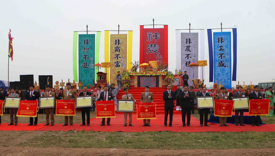 Tặng cờ thi đua của UBND tỉnh Hà Nam cho các xã có thành tích xuất sắc trong xây dựng nông thôn mới. (Ảnh: Thanh Tùng/TTXVN)