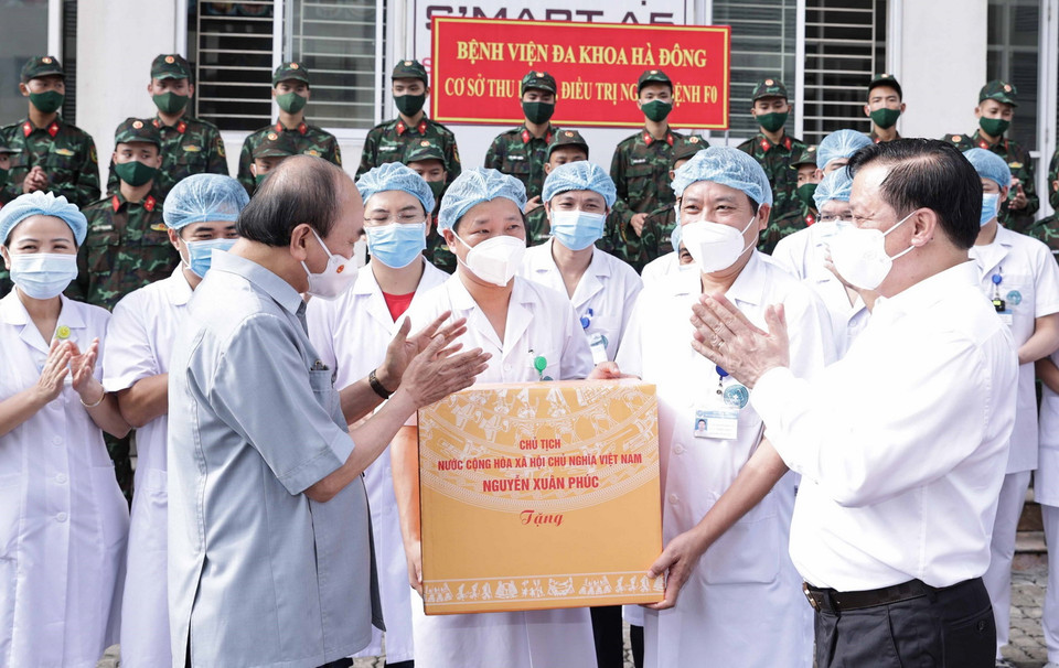  Chủ tịch nước Nguyễn Xuân Phúc tặng quà các nhân viên y tế làm việc cơ sở thu dung, điều trị bệnh nhân COVD-19 của Bệnh viện Đa khoa Hà Đông. (Ảnh: Thống Nhất/TTXVN) 