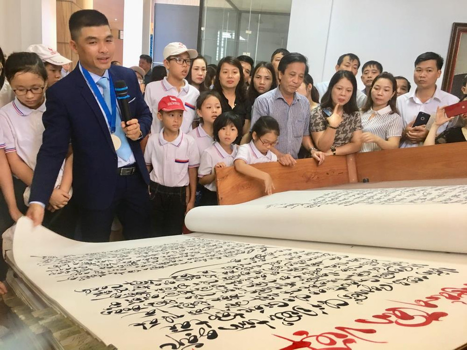 Những tác phẩm thư pháp chữ Việt trong cuốn sách được tác giả Võ Dương thực hiện thủ công bằng mực tàu và acrylic trên 250 trang và được ép keo Nhật 5 lớp. (Ảnh: Võ Dung/TTXVN)